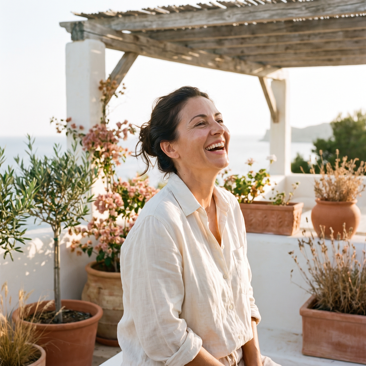 Mujer riendo en una terraza mediterránea