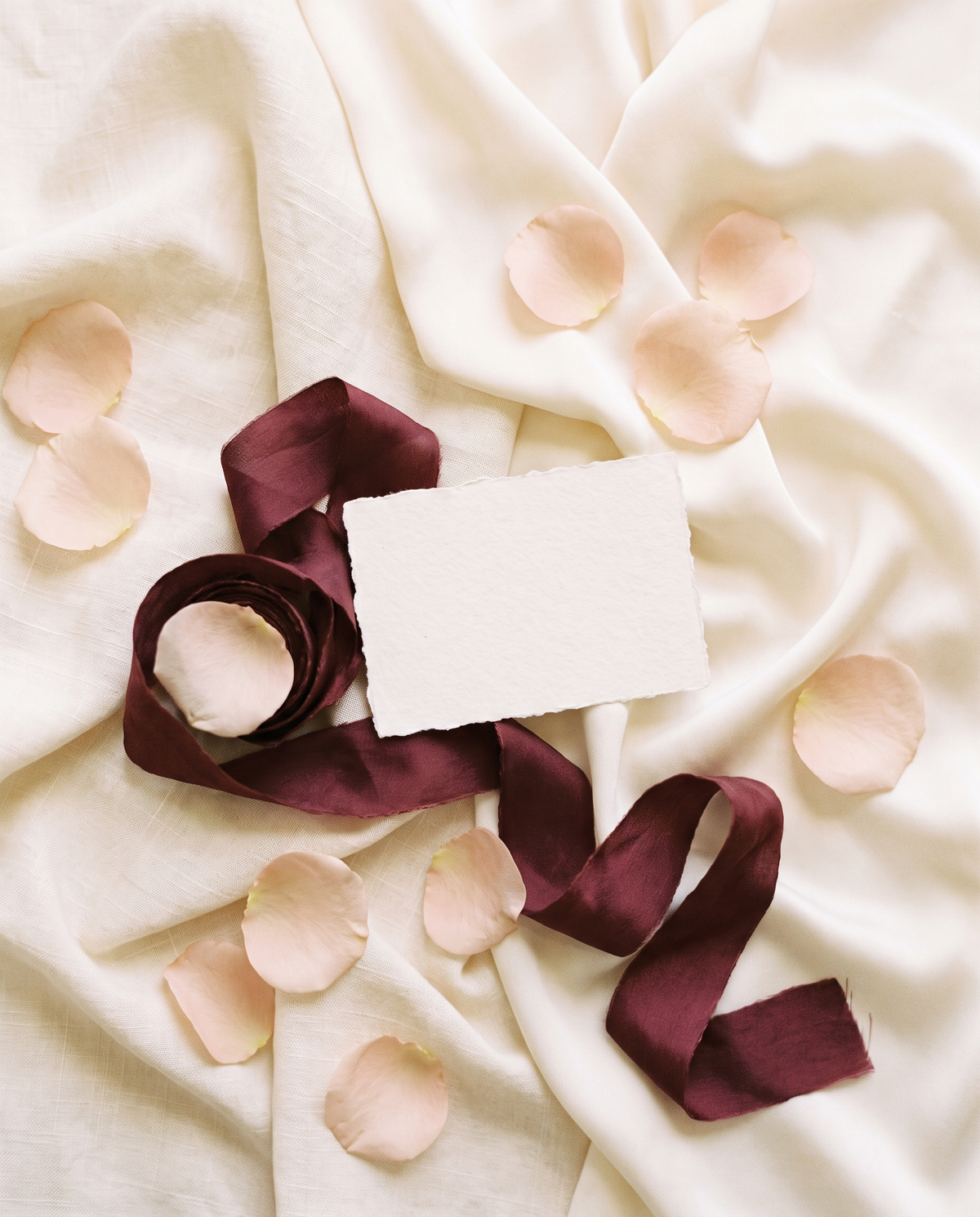 Tela de lino con pétalos de rosa y cinta burdeos
